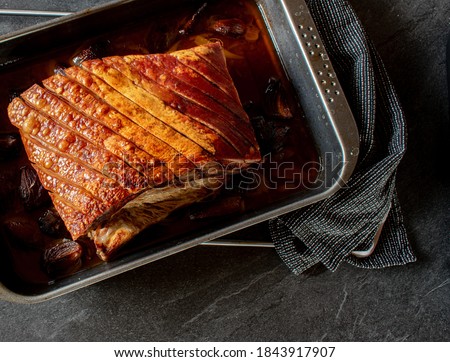 Overhead view of roasted pork belly with crust on a baking tray Royalty-Free Stock Photo #1843917907