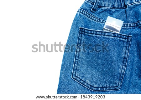 Blue jeans with parfume in pocket in white background.