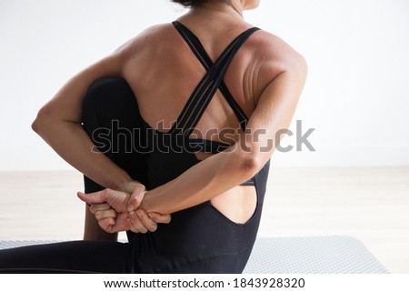 unrecognizable woman practicing ashtanga yoga on a yoga mat Royalty-Free Stock Photo #1843928320