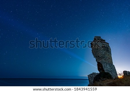 man with a powerful lantern illuminating the starry sky at night in a collapsed tower