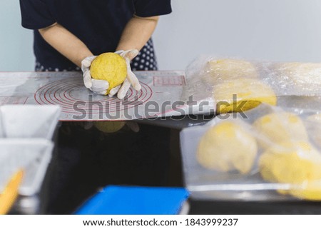 Woman hands preparing bread dough on black marble table