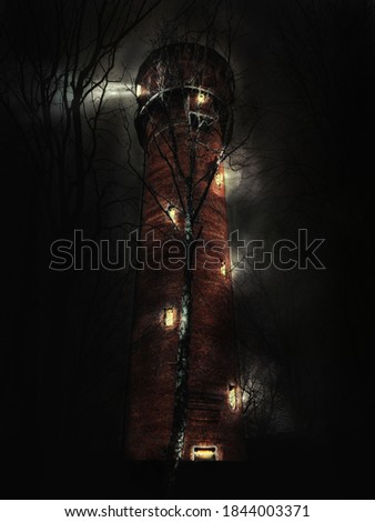 Old lighthouse at night with light in the windows near the forest. Mysterious ancient tower in the dark.