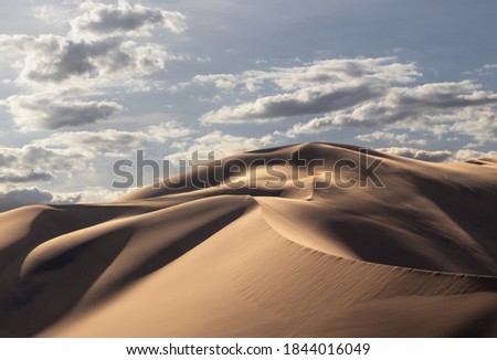 Golden sand dune 7 and white clouds on a sunny day in the Namib desert. Fantastic place for travelers and photographers.