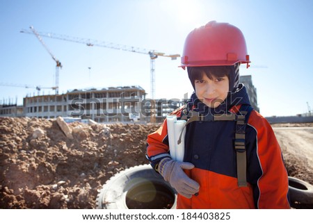 young builder in a red helmet on a background of construction