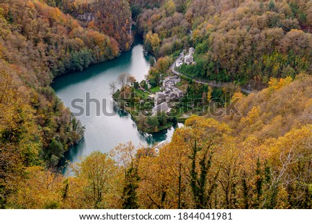 Superb aerial view of the lake and the ancient village of Isola Santa, Lucca, Italy, with the typical autumn foliage
