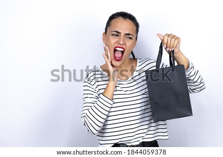 Young beautiful woman holding a black shopping bag touching mouth with hand with painful expression because of toothache or dental illness on teeth. Black Friday