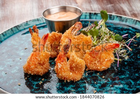 Fried tiger prawns with sauce on a decorative plate