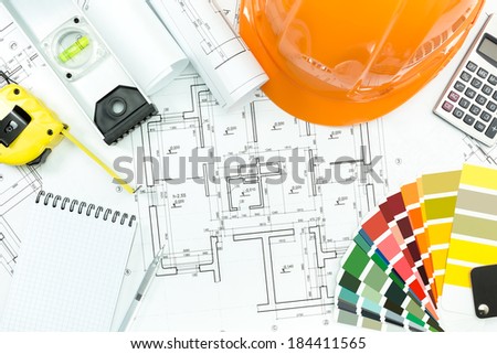 Engineer workplace with safety helmet, blueprint, and measuring tools