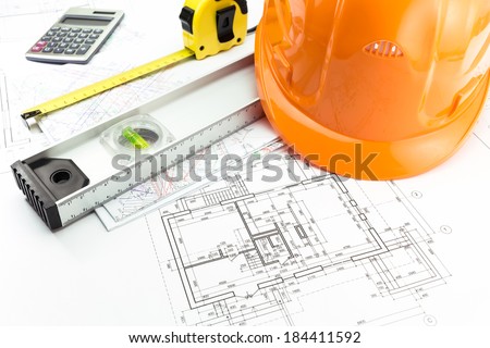 Blueprints with drawing of project, safety helmet and work tools
