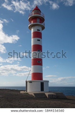 Faro Sardina light house in front of blue sky and sea Royalty-Free Stock Photo #1844156560