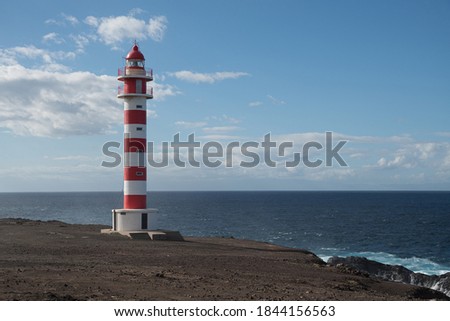 Faro Sardina light house in front of blue sky and sea Royalty-Free Stock Photo #1844156563