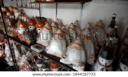 Small Christmas wooden toys of santa claus sits in the house in plastic packaging