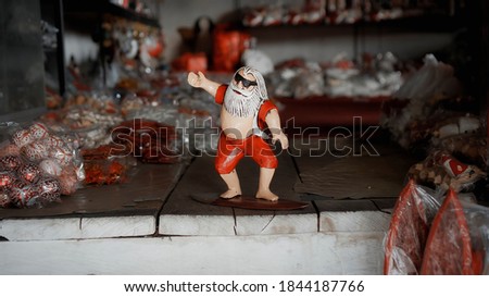 Small Christmas wooden toys of santa claus stay on a  surfboard in the house