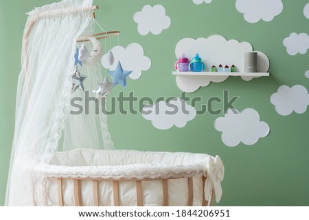 cloud stickers on green wall mosquito net on wooden cradle Royalty-Free Stock Photo #1844206951