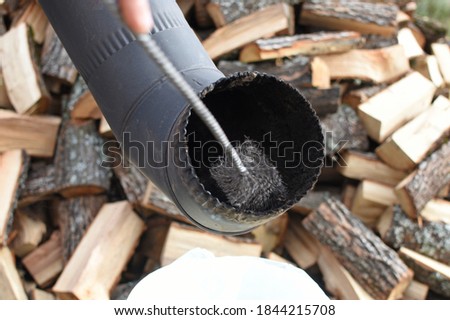 Man cleaning chimney pipe outside. Cleaning a wood burning stove. Chimney sweep cleaning Royalty-Free Stock Photo #1844215708