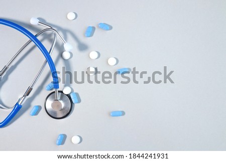 Pills or pills lying next to stethoscope on gray background with conceptual copy space medicine, healthcare and medication treatment Royalty-Free Stock Photo #1844241931