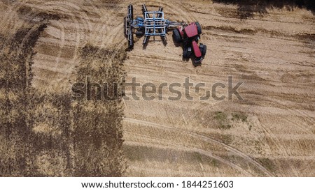 Aerial view of tractor or combine harvester works in field. Industrial agriculture