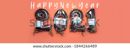 Balloon Bunting for celebration of New Year 2021 made from Silver Number Balloons with protective face masks on pink background. Holiday Party Decoration or postcard concept as New Reality