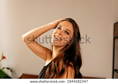 Smiling attractive girl posing at camera with bright makeup and wavy hair celebrating birthday