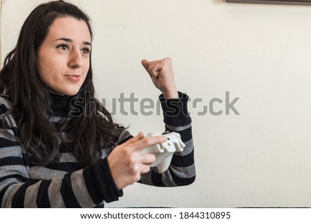 A young girl holding a white video game controller cellebrating