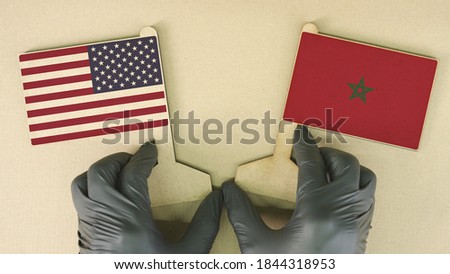 Flags of the USA and Morocco made of recycled paper on the cardboard table
