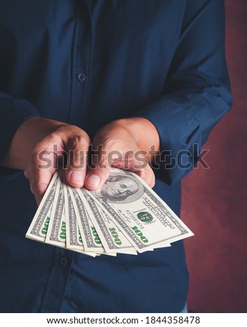 Close-up of hands holding USD Dollars banknote with a vintage background. Space for text. Concept of business and finance.