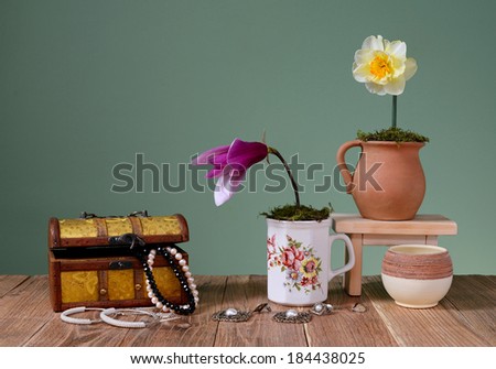 Jewelry in box and flowers on wooden table