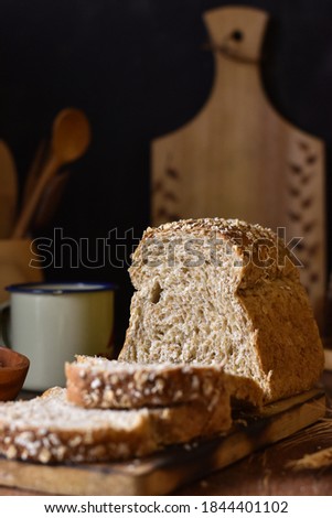 Grainy texture of Whole wheat bread in slice.  eye level view, in darkmood photography with wooden background.