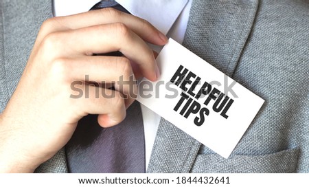 businessman holding a card with text HELPFUL TIPS