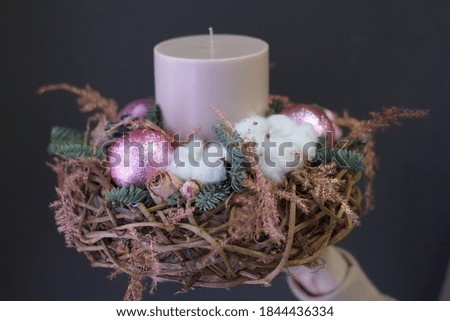 Female hands holding new year composition of fir branches, christmas decorations and candles, gift concept, selective focus