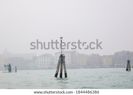 Venetian lagoon in foggy day, Venice, Italy. View of  Venetian buildings. building and things dissolving, dreamy landscape, mist. Selective focus.