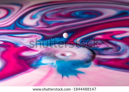 Drop falls into paint surface