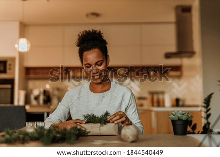 African woman making gifts, using plants for decoration.