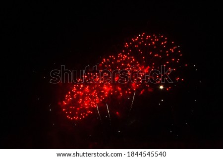 Beautiful red firework isolated on black background. Firework explode night sky close up. Template to design Greeting card for Christmas holidays, New year, anniversary, independence day, birthday