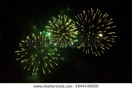 Beautiful Golden and green firework isolated on black background. Firework explode night close up. Template to design Greeting card for Christmas holidays, New year, anniversary, independence day