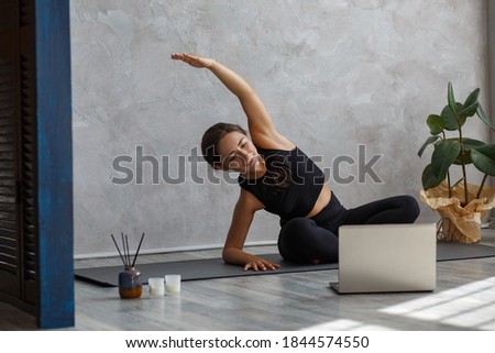 Young sporty female yoga instructor coaching online, making video of yoga lessons on laptop camera. Beautiful woman practicing yoga poses. Yoga postures, meditation, relaxation, wellbeing and health. Royalty-Free Stock Photo #1844574550
