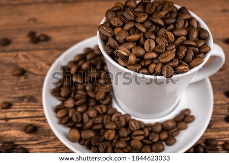 Coffee Cup and coffee beans on a wooden background.