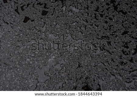 black and wet asphalt background, surface and structures after rain