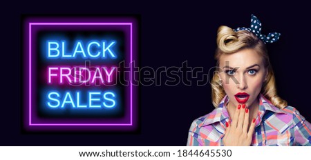 Excited surprised pinup woman. Pin up girl with open mouth. Blond model at retro fashion and vintage concept. Dark background. Black Friday sales neon light sign. Awe, wow, omg.