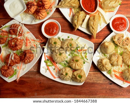 Variety Nepalese traditional dumpling momos served with tomato ketchup and fresh salad. Royalty-Free Stock Photo #1844667388