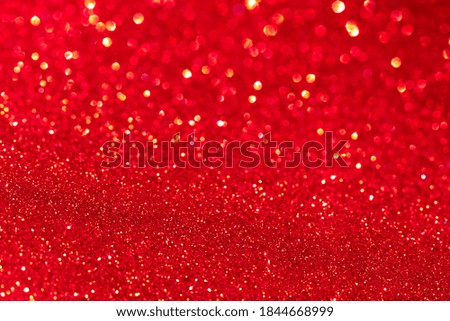 Red glitter texture Christmas abstract background. Defocused lights.