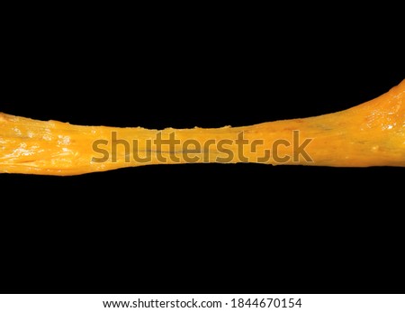 Stretching cheese isolated on black background. Ingredient preparation for design. Melting cheese. Royalty-Free Stock Photo #1844670154