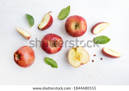 Red apples, whole and pieces with leaves on a white background. Poster. Royalty-Free Stock Photo #1844680555