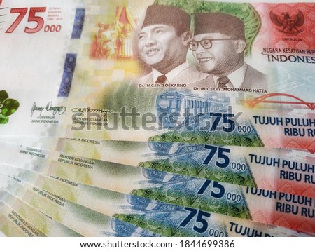 Stack of special edition Indonesian Currency of 75000 Rupiah or duit or uang from Bank Indonesia regarding the 75th of Independence Day of Indonesia in 2020. 