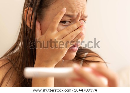Stressed worried woman waiting for a pregnancy test result.