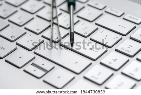 Laptop repair, screwdrivers close-up on a gray keyboard. Computer service macro