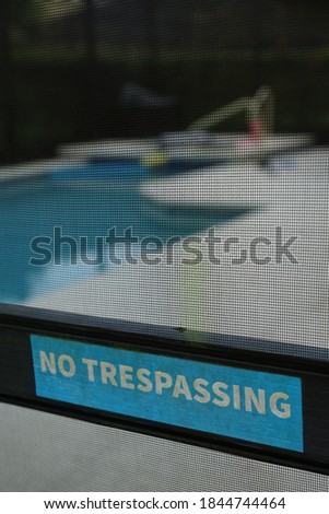 no trespassing blue warning sign on pool enter backyard