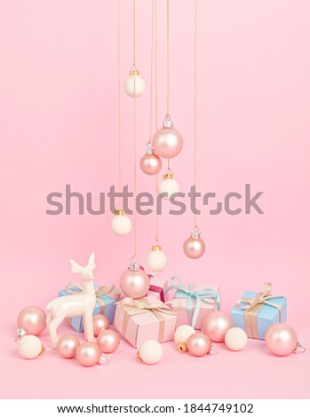 White deer with christmas ornaments over pink background. Minimal picture for winter holidays, xmas and new year celebration greeting card