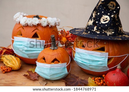 Halloween facial mask as a jack o lantern pumpkin wearing a medical face protection as a symbol for disease control and virus infection and coronavirus or covid-19