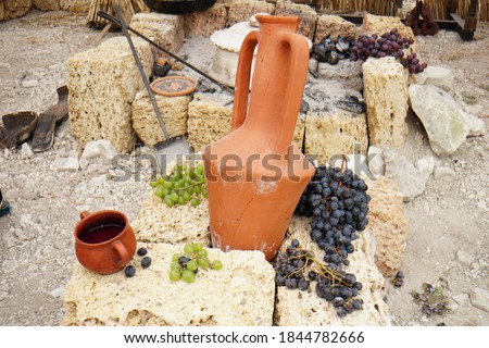 still-life. pottery grapes and fruit on a stone background High quality photo